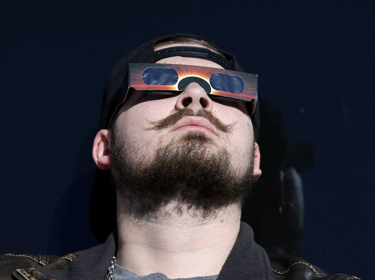 Logen Swartley watches a partial solar eclipse at the observation deck at The Strat on Monday, ...