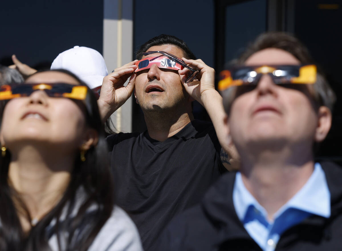 People watch a partial solar eclipse at the observation deck at The Strat, on Monday, April 8, ...