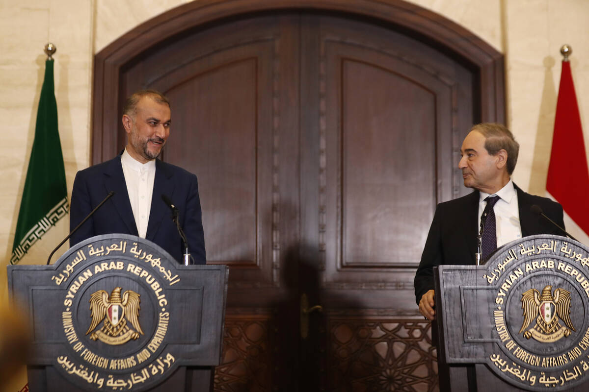 Syrian Foreign Minister Faisal Mekdad, right, speaks with Iranian Foreign Minister Hossein Amir ...