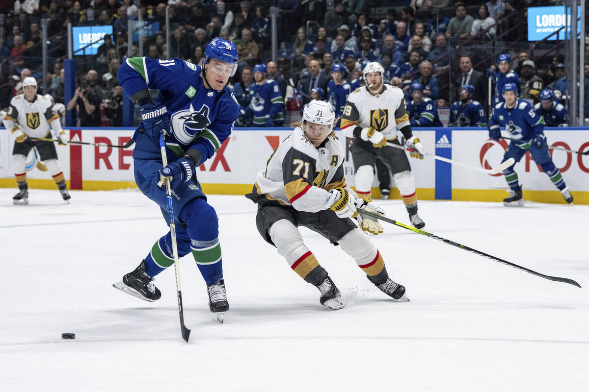 Vancouver Canucks' Nikita Zadorov (91) and Vegas Golden Knights' William Karlsson (71) vie for ...