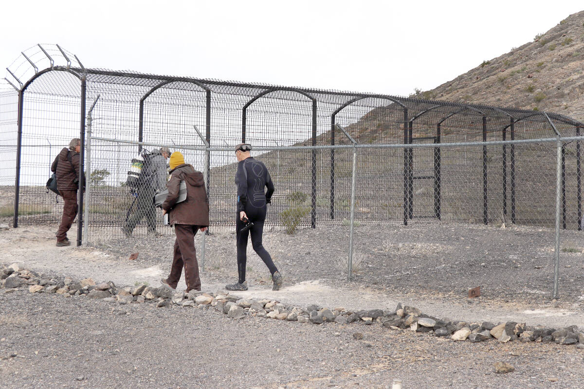 Biologists walk toward Devils Hole in Death Valley National Park on Sunday, April 7, 2024. Bein ...