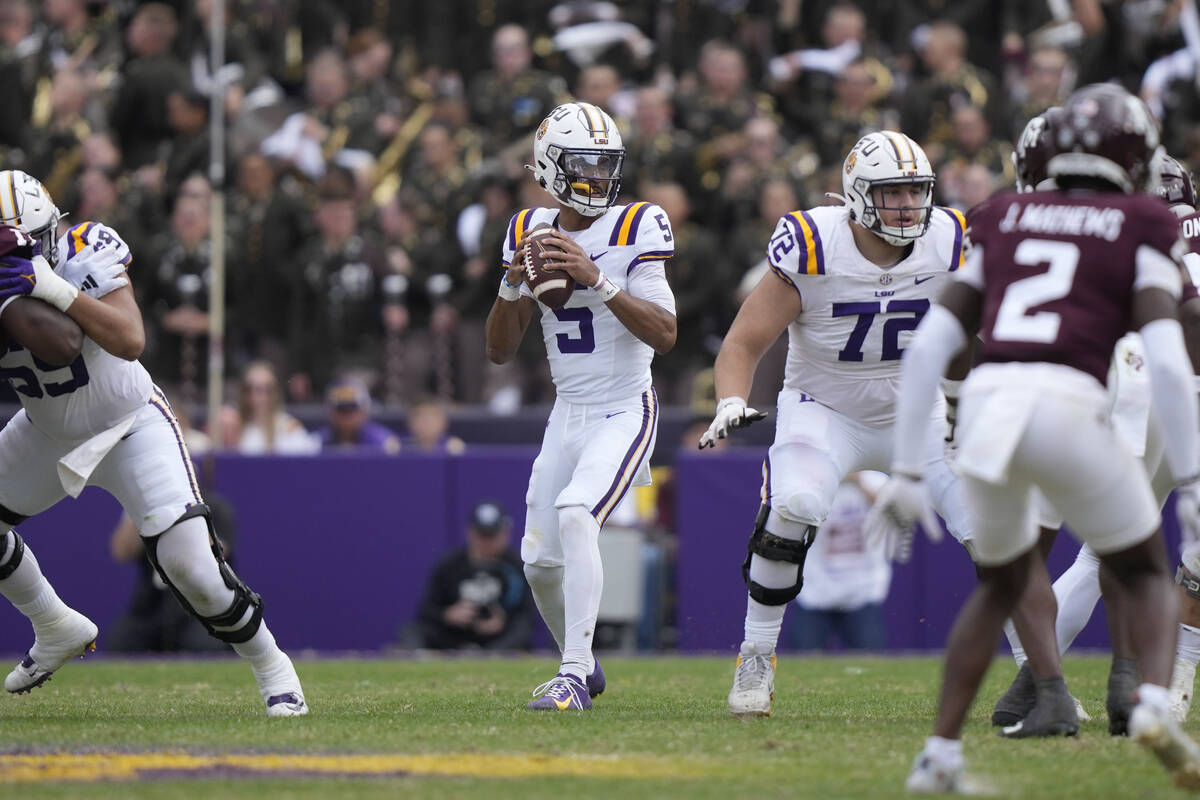 LSU quarterback Jayden Daniels (5) drops back to pass in the second half of an NCAA college foo ...