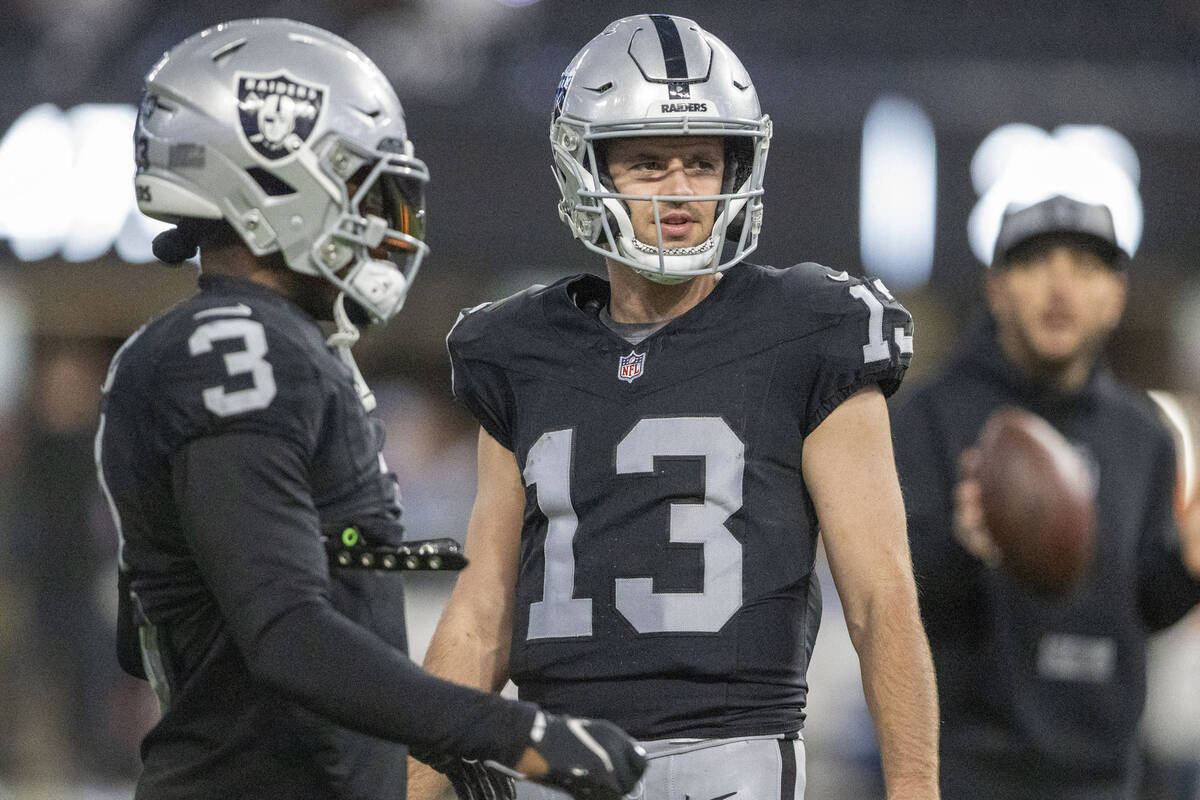 Raiders wide receiver Hunter Renfrow (13) walks past wide receiver DeAndre Carter (3) before an ...