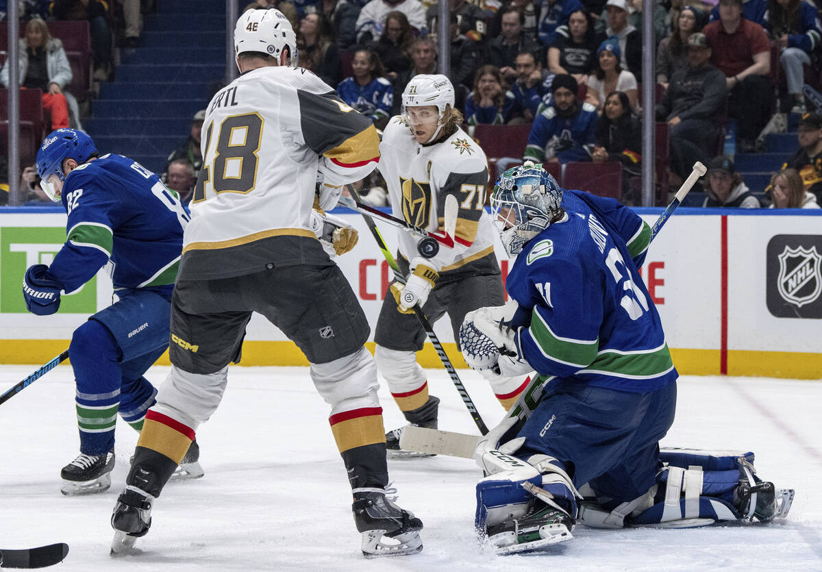 Vegas Golden Knights' Tomas Hertl (48) tries to tap in a shot as William Karlsson (71) and Vanc ...