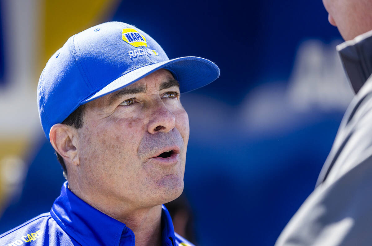 Funny Car driver Ron Capps talks to a friend in the pits during Day 2 of NHRA Nationals at the ...