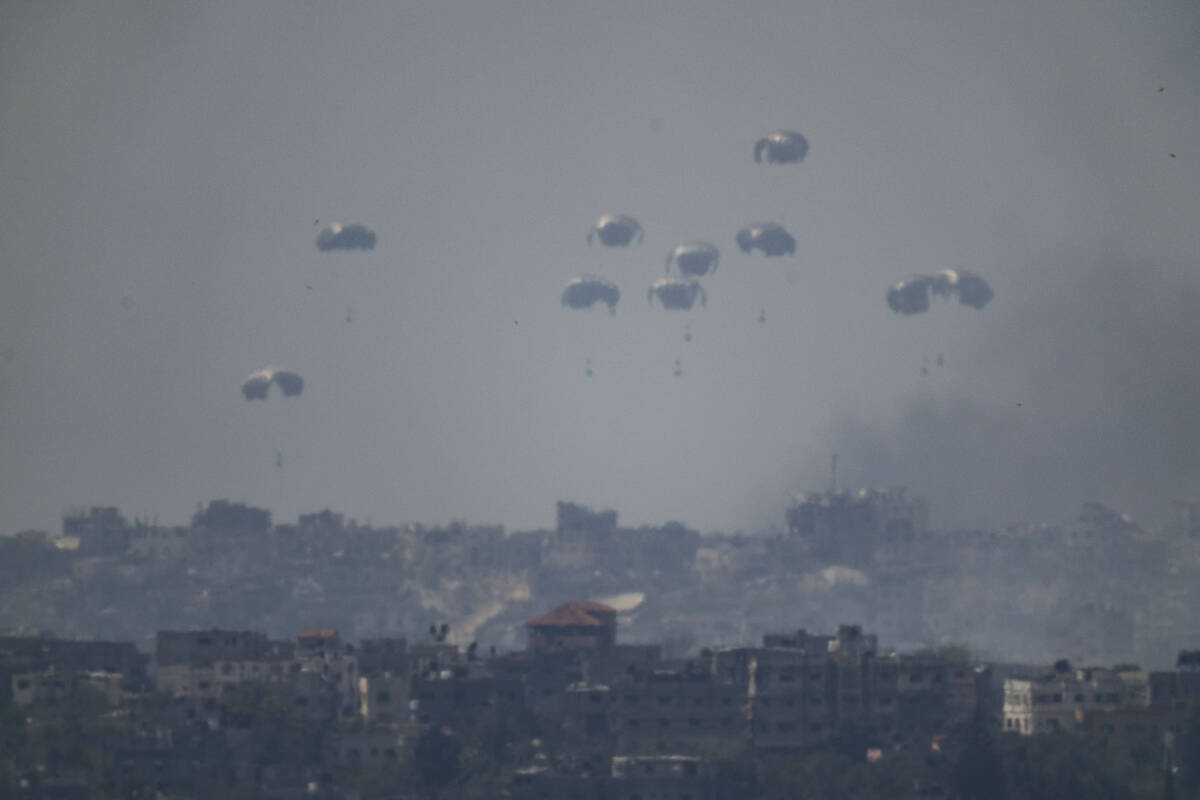 Parachutes drop supplies into the northern Gaza Strip as seen from southern Israel, Tuesday, Ap ...