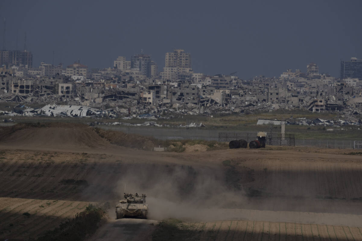 Israeli soldiers move on the top of a tank near the Israeli-Gaza border, as seen from southern ...