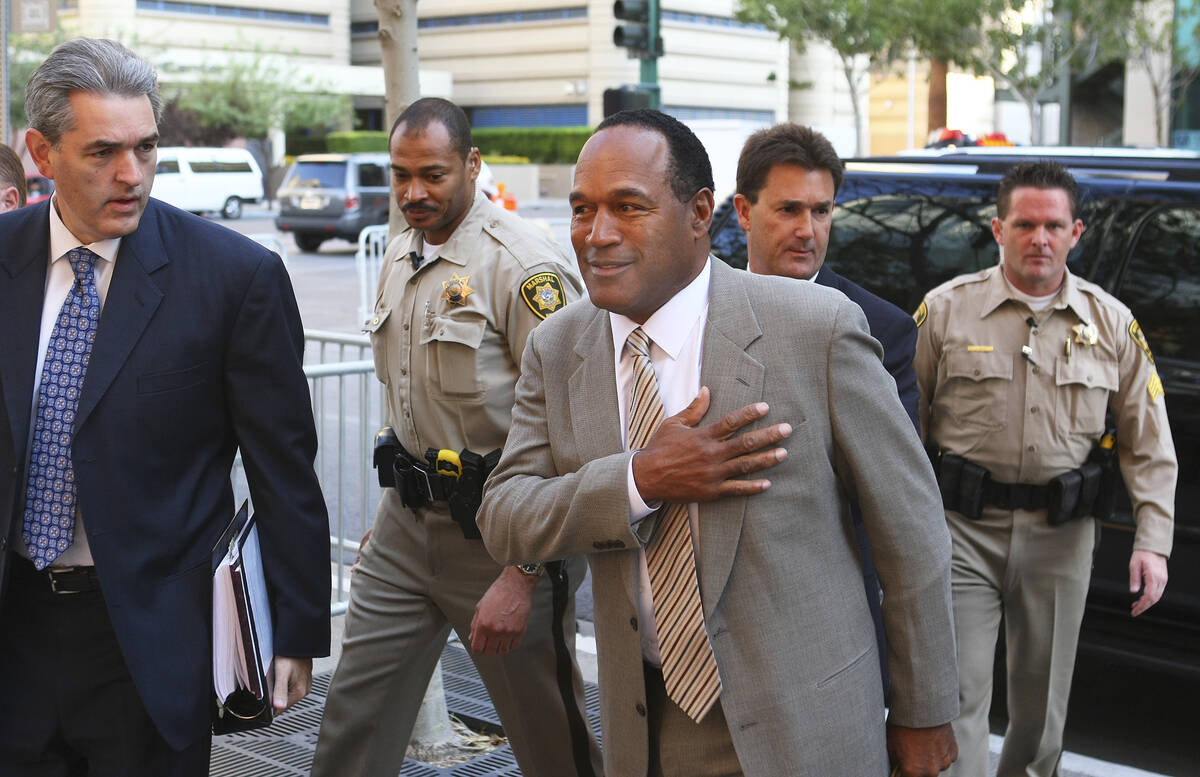 Escorted by court marshals, O.J. Simpson, center, is accompanied by his attorneys Gabriel Grass ...