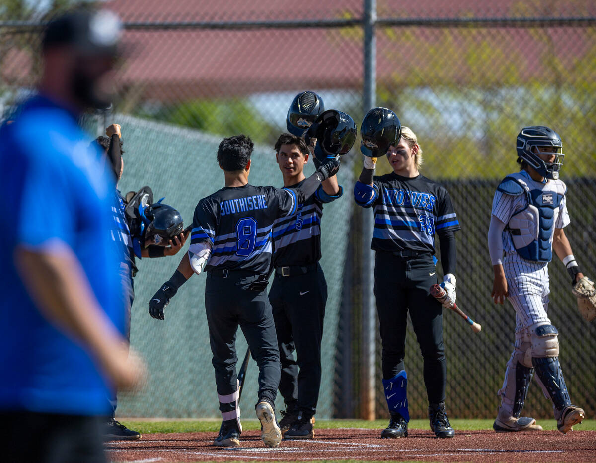 Basic runner Tate Southisene celebrates a score with teammates against Spring Valley during the ...