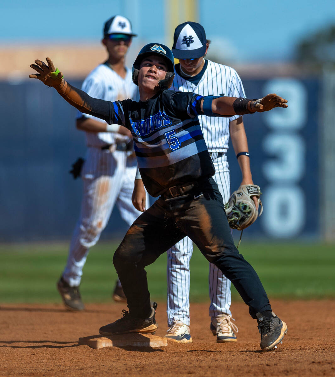 Basic runner Lyndon Lee celebrates his double arriving at second base before Spring Valley infi ...