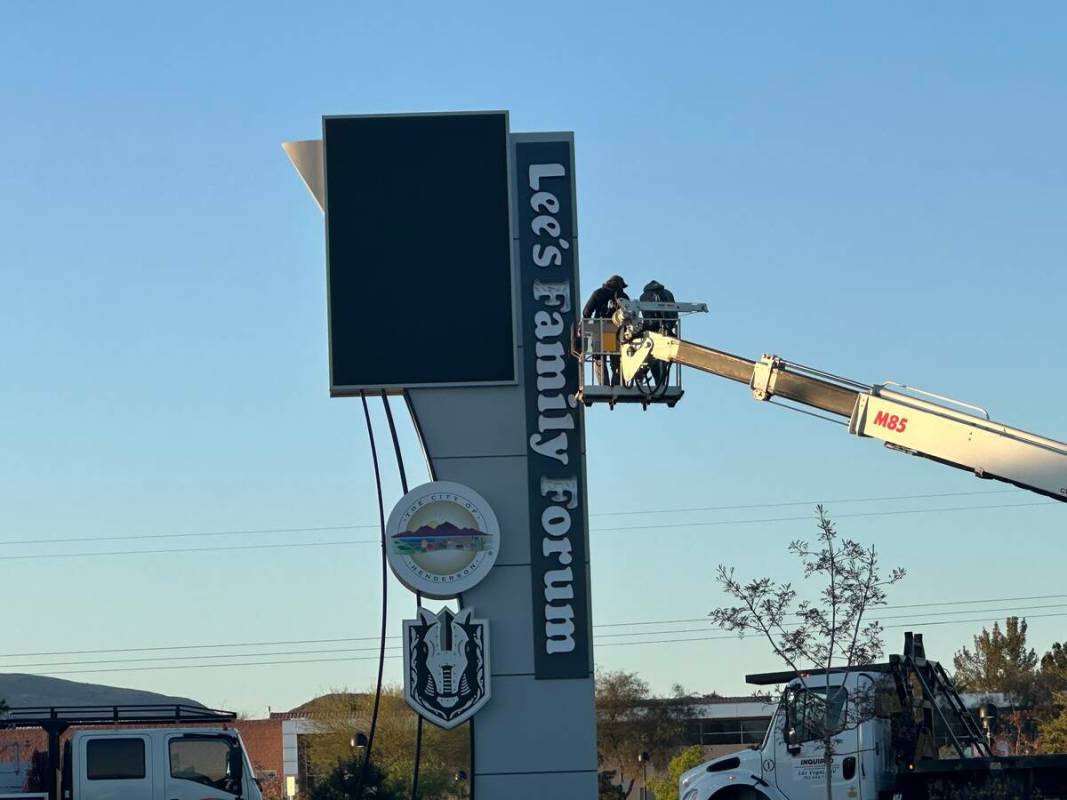 Workers update signage at Lee's Family Forum, the Henderson arena formerly named Dollar Loan Ce ...