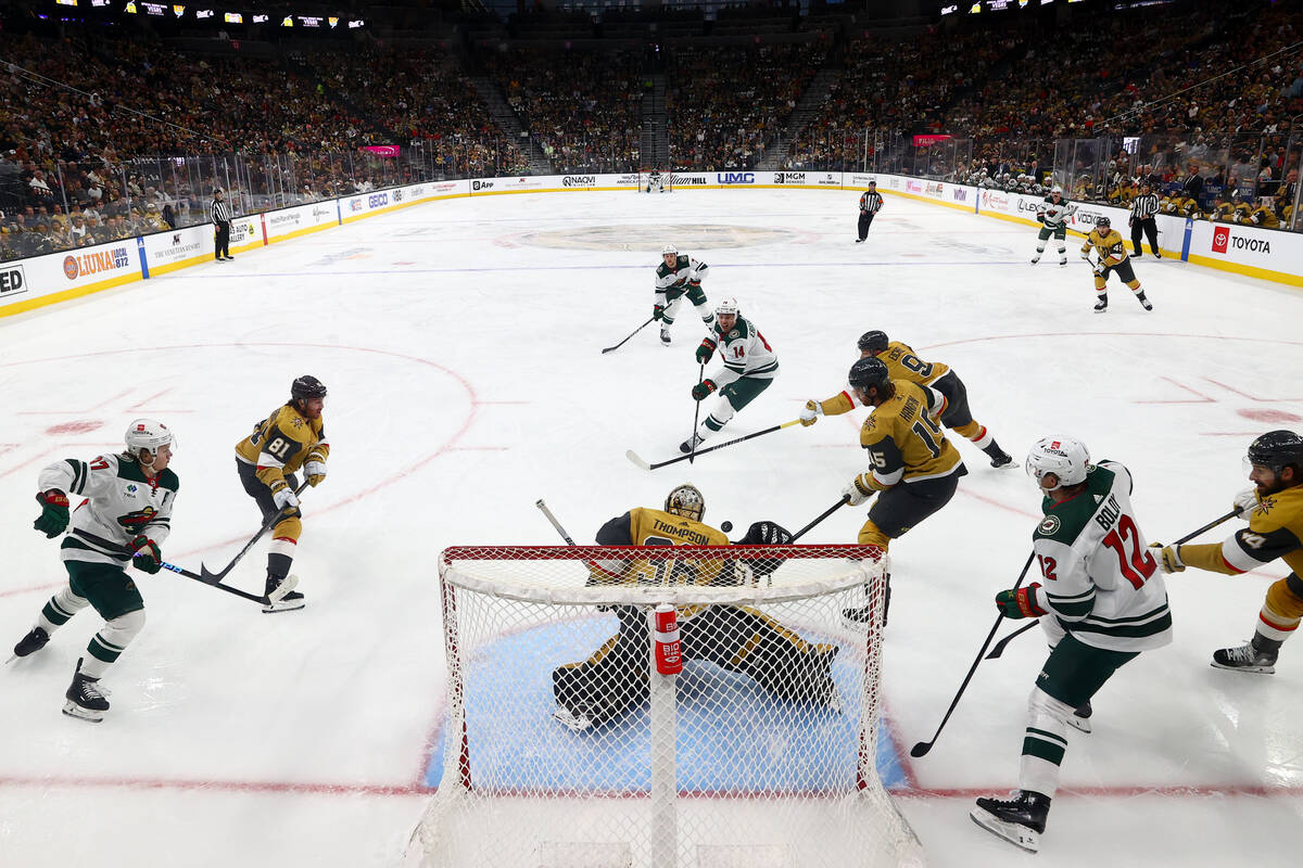 Golden Knights goaltender Logan Thompson (36) saves the puck after Wild center Joel Eriksson Ek ...