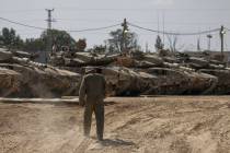 Israeli soldiers work on tanks at a staging ground near the border with the Gaza Strip, in sout ...