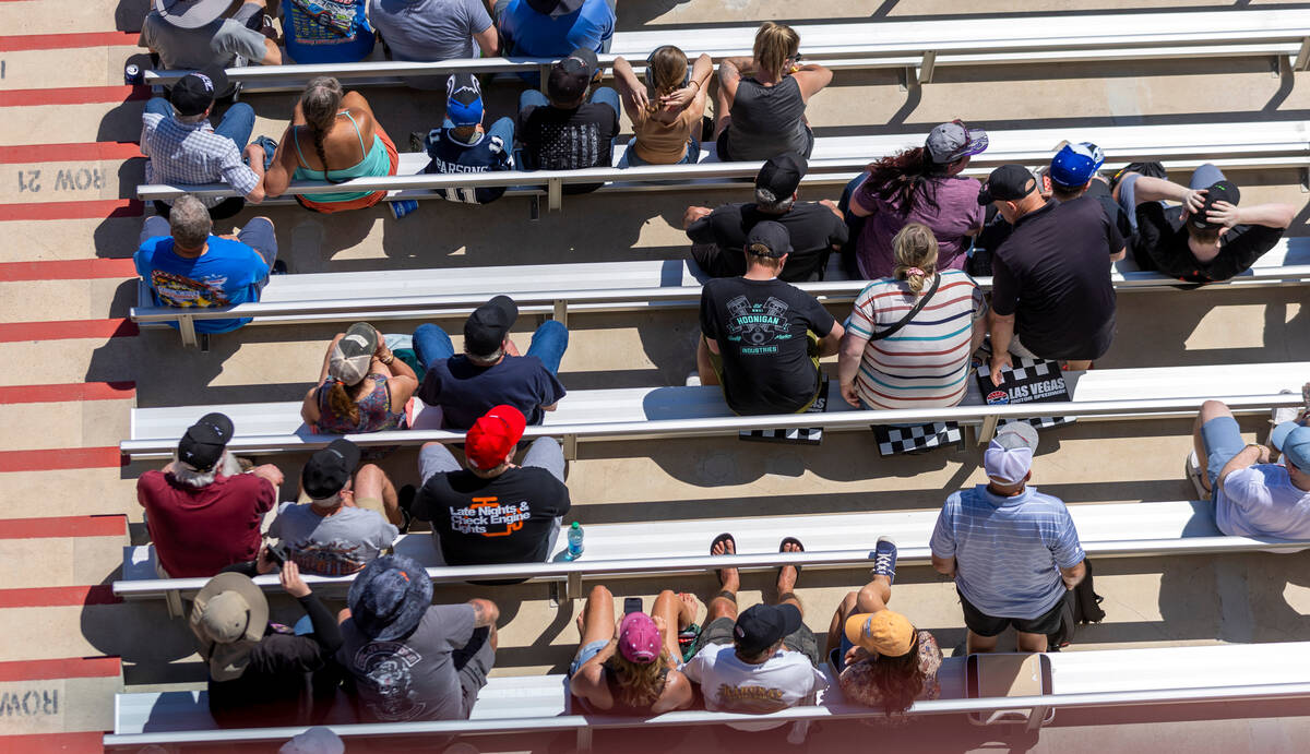 Fans sit on Las Vegas racing mats in the stands during Day 2 of NHRA 4-Wide Nationals on " ...