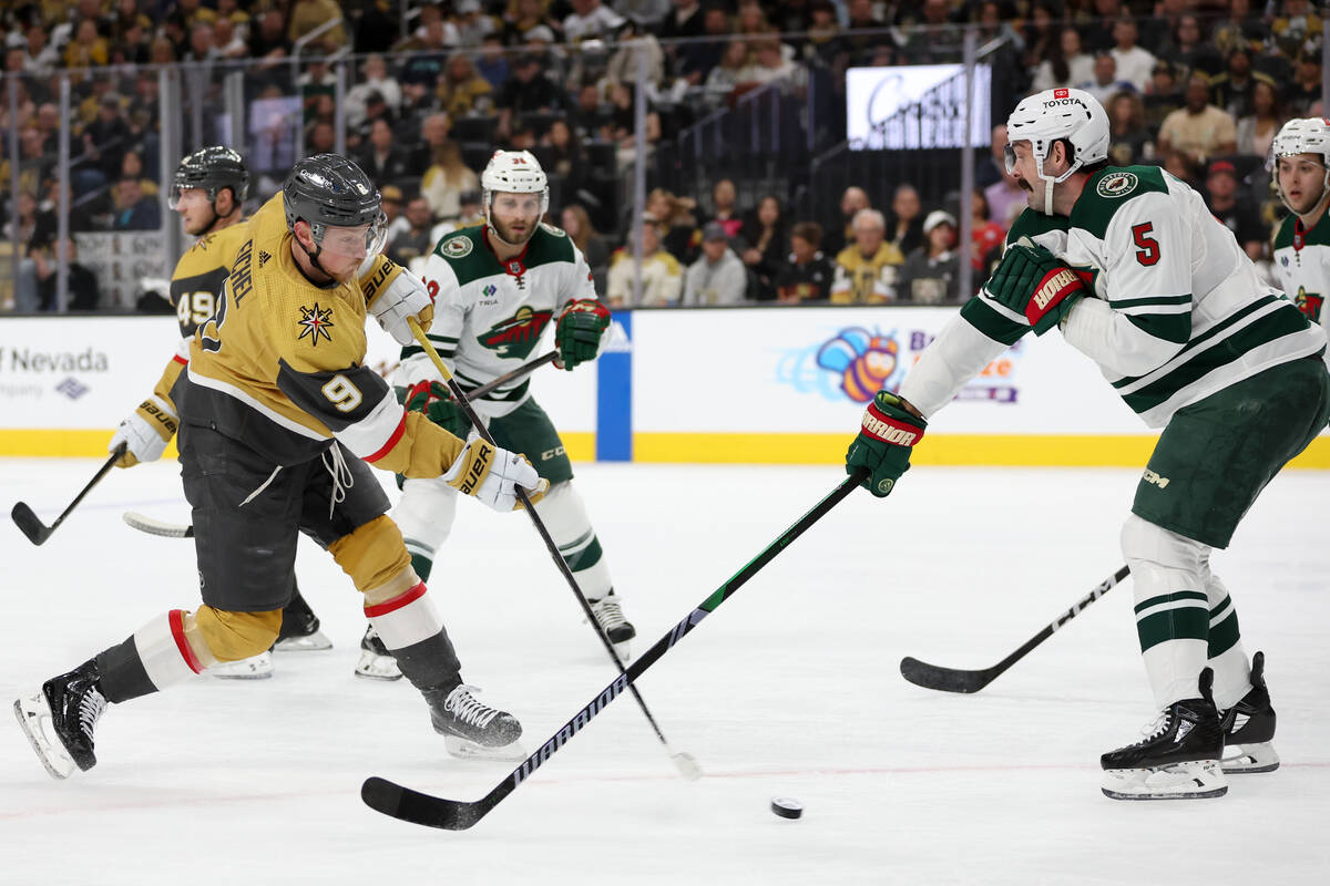 Golden Knights center Jack Eichel (9) shoots at the net while Wild defenseman Jake Middleton (5 ...