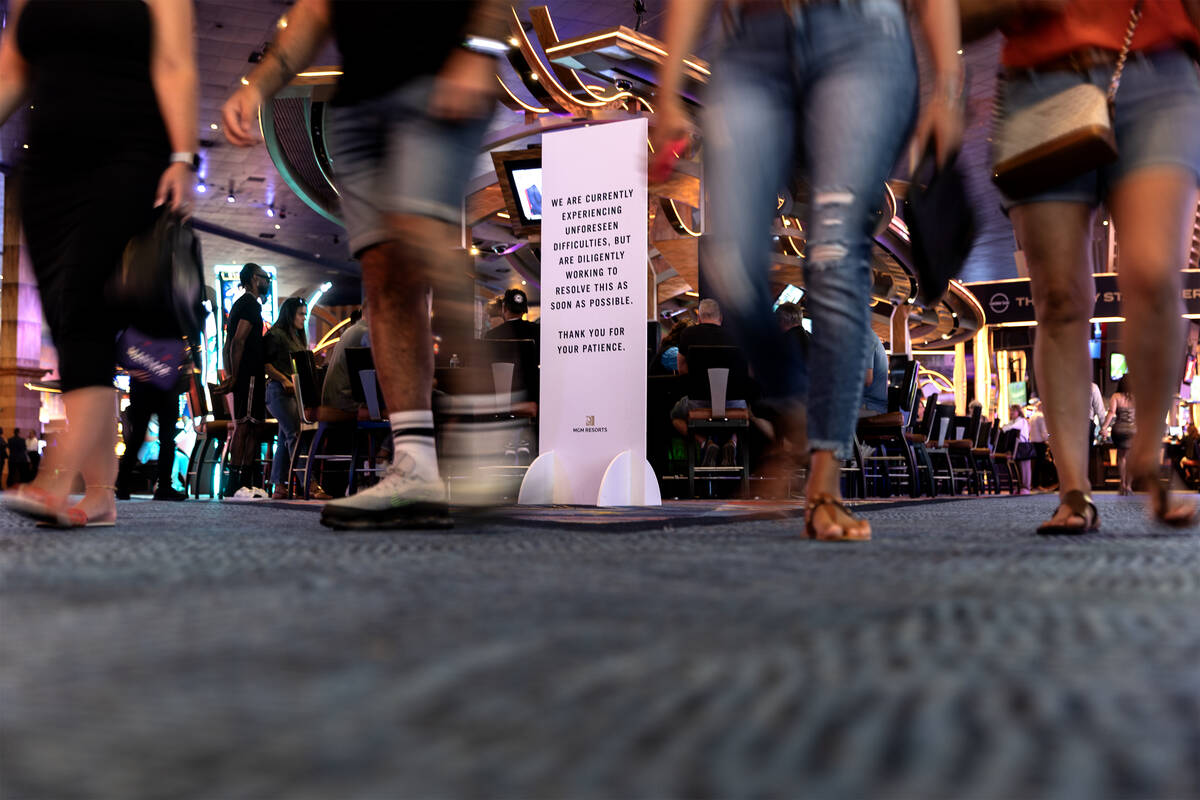 Guests walk through New York New York past a sign about MGM’s “unforeseen difficulties” o ...