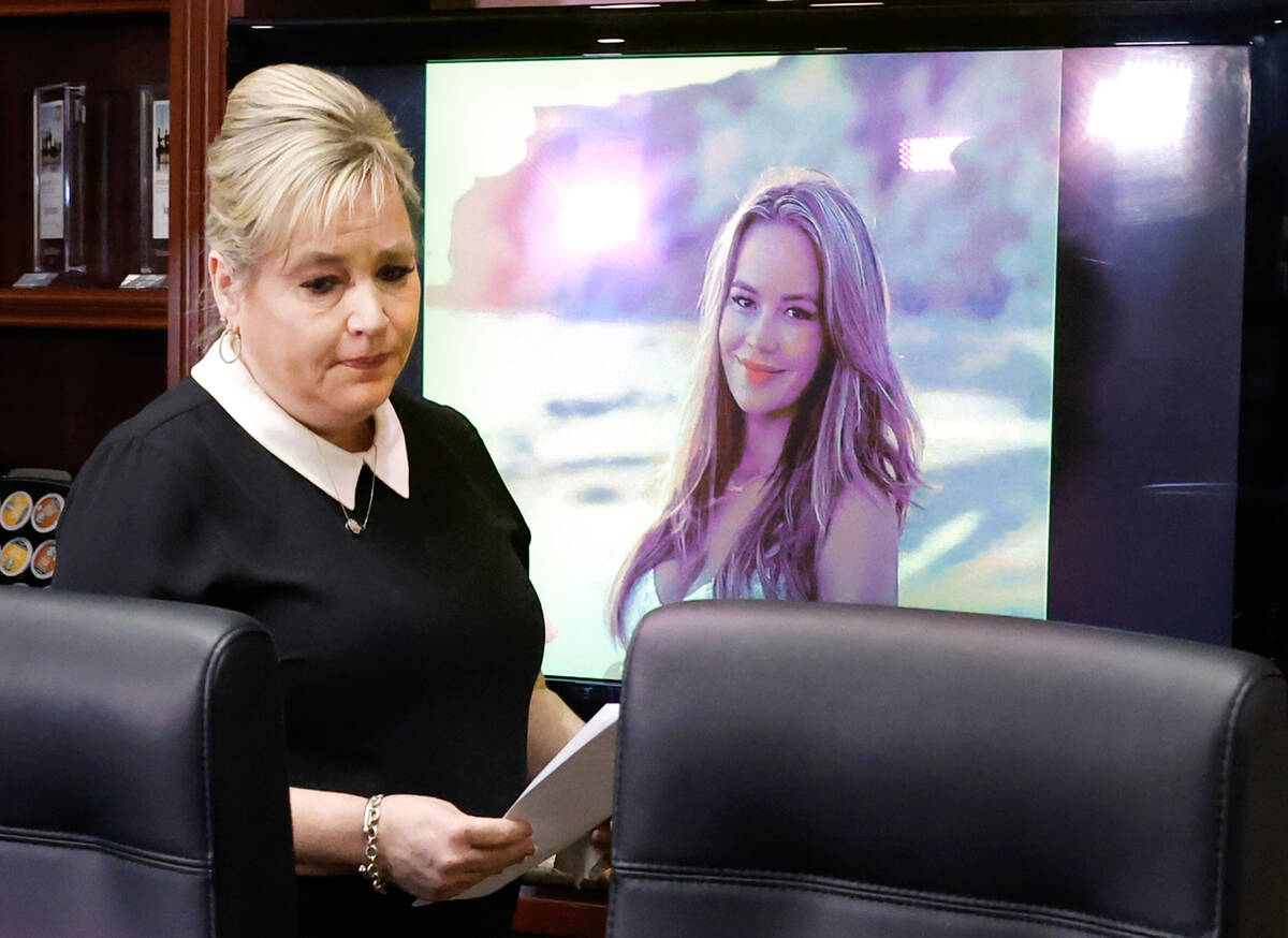 Julie Page, the mother of a shooting victim Ashley Prince, walks past a photograph of Prince be ...