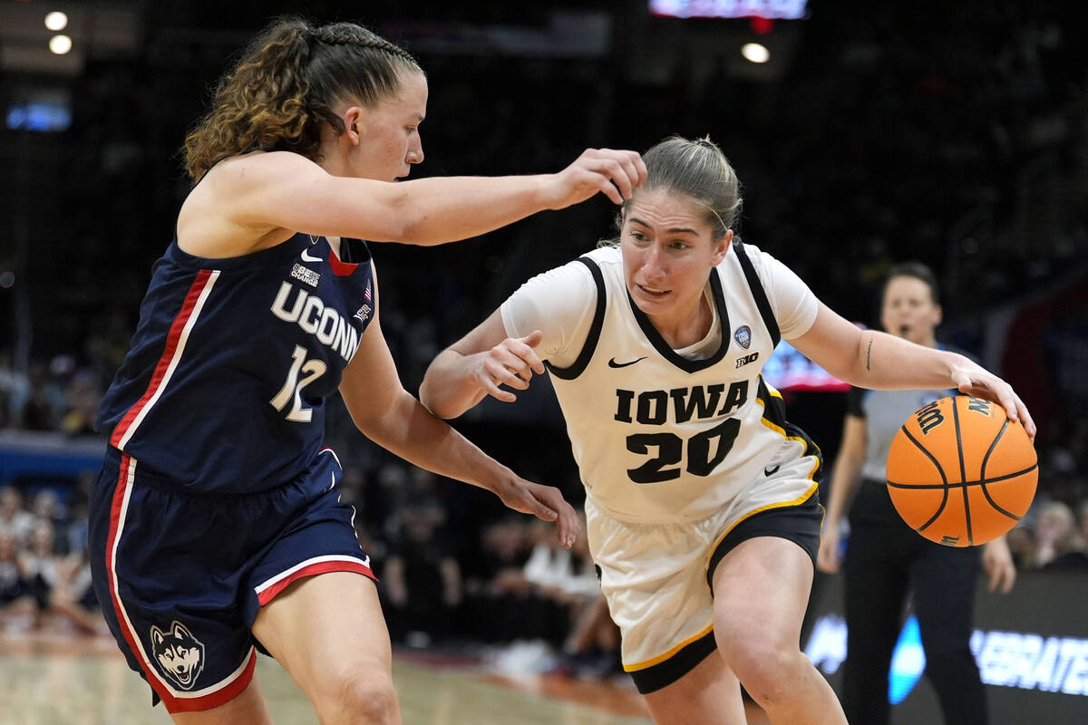 Iowa guard Kate Martin (20) drives past UConn guard Ashlynn Shade (12) during the second half o ...