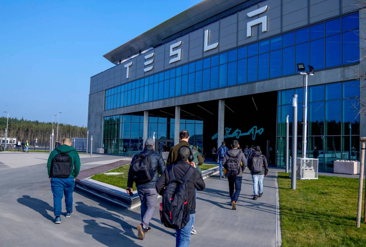 People walk to the Tesla Gigafactory for electric cars in Gruenheide near Berlin, Germany,March ...