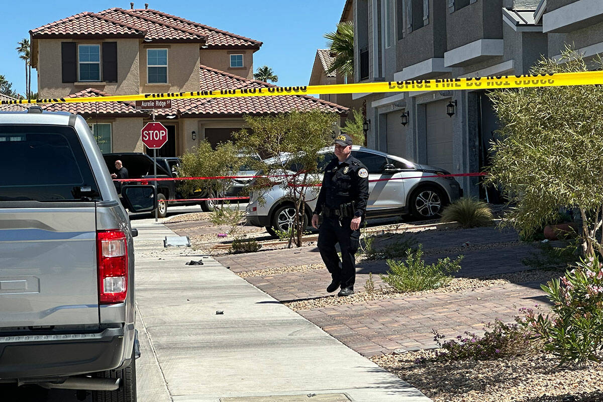 Police stand in front of a Henderson home on on Sunday, April 14, 2024, where a multi-day shoot ...