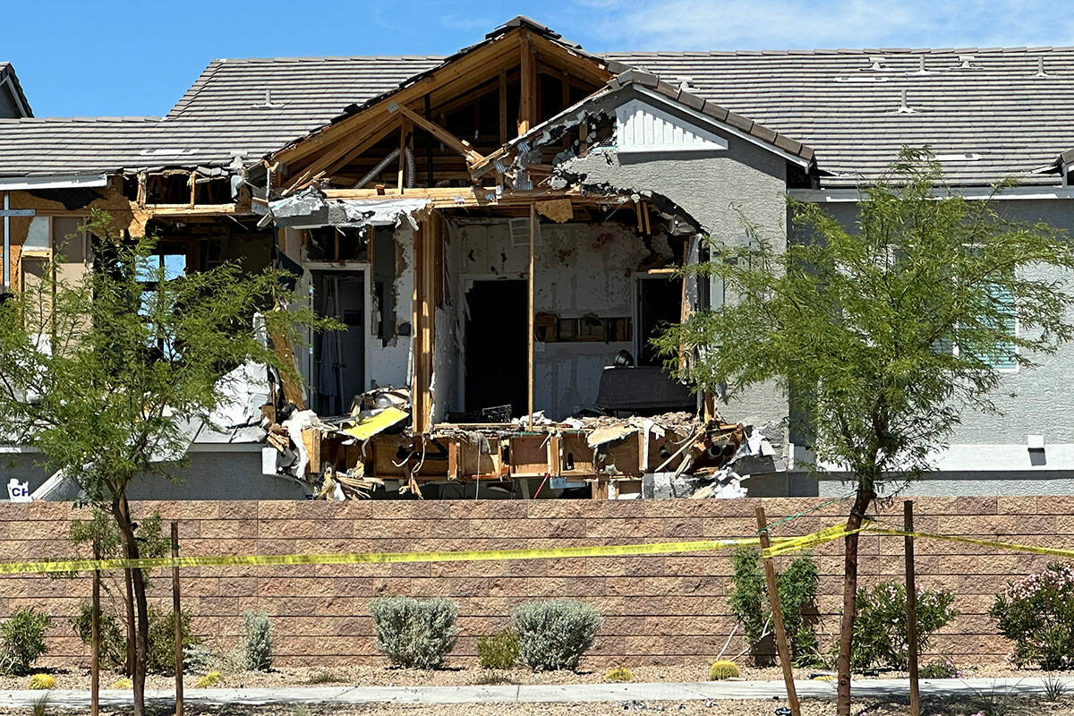 Police stand in front of a Henderson home on on Sunday, April 14, 2024, where a multi-day shoot ...