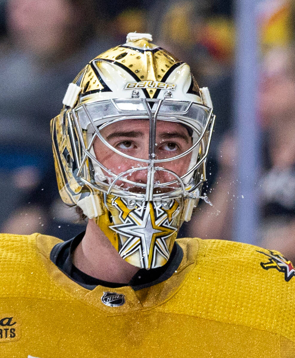 Golden Knights goaltender Logan Thompson (36) spits some water on a timeout against the Chicago ...