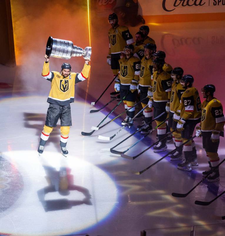 Golden Knights right wing Mark Stone (61) carries out the Stanley Cup during the raising of the ...