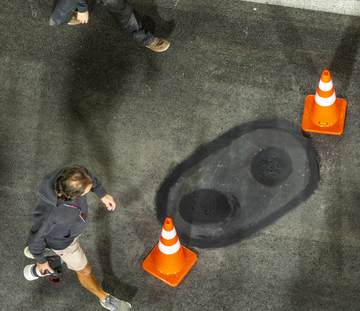 One of the valve covers secured and the pavement around smoothed by a crew from Las Vegas Pavin ...