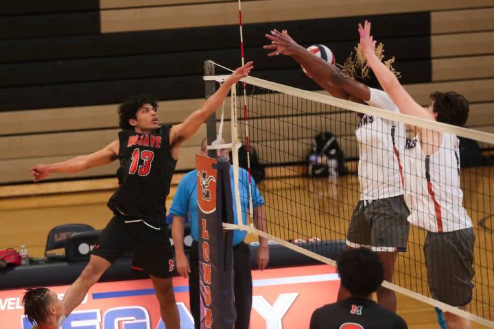 Mojave outside hitter Nate Sherrod (13) gets the ball around Legacy outside hitters De'Qua Simo ...