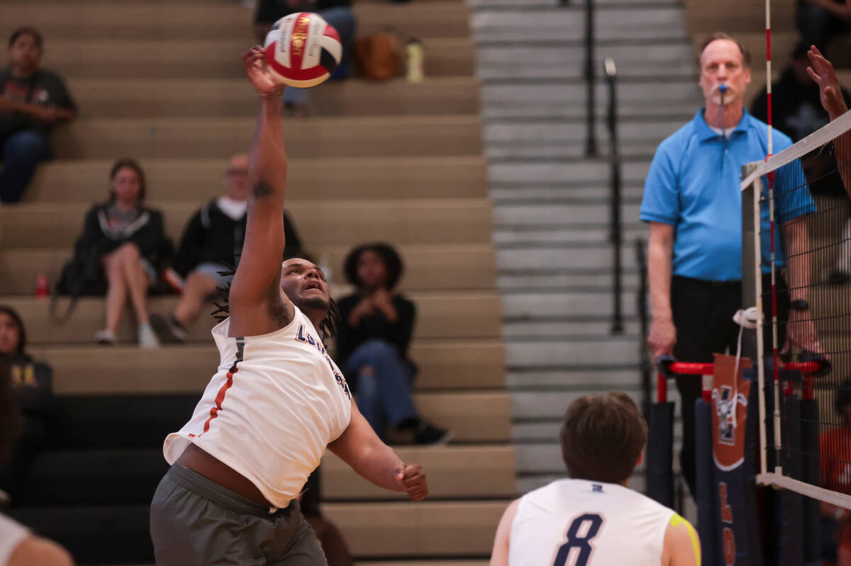 Legacy's Jordan Johnson (14) spikes the ball against Mojave during a boys high school volleybal ...