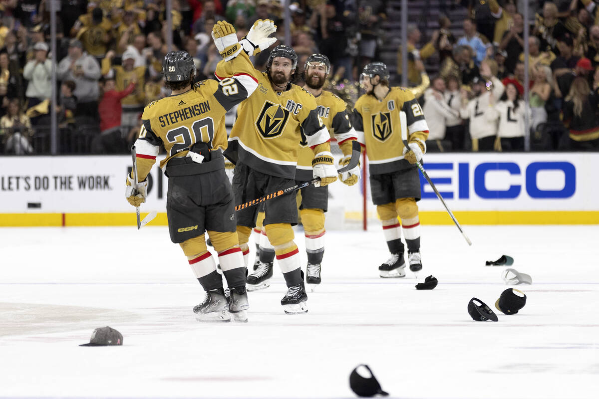 Hats litter the ice while Golden Knights right wing Mark Stone (61) slaps hands with center Cha ...