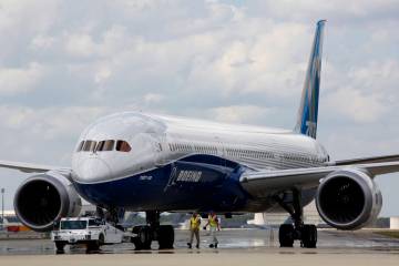 FILE - Boeing employees walk the new Boeing 787-10 Dreamliner down towards the delivery ramp ar ...