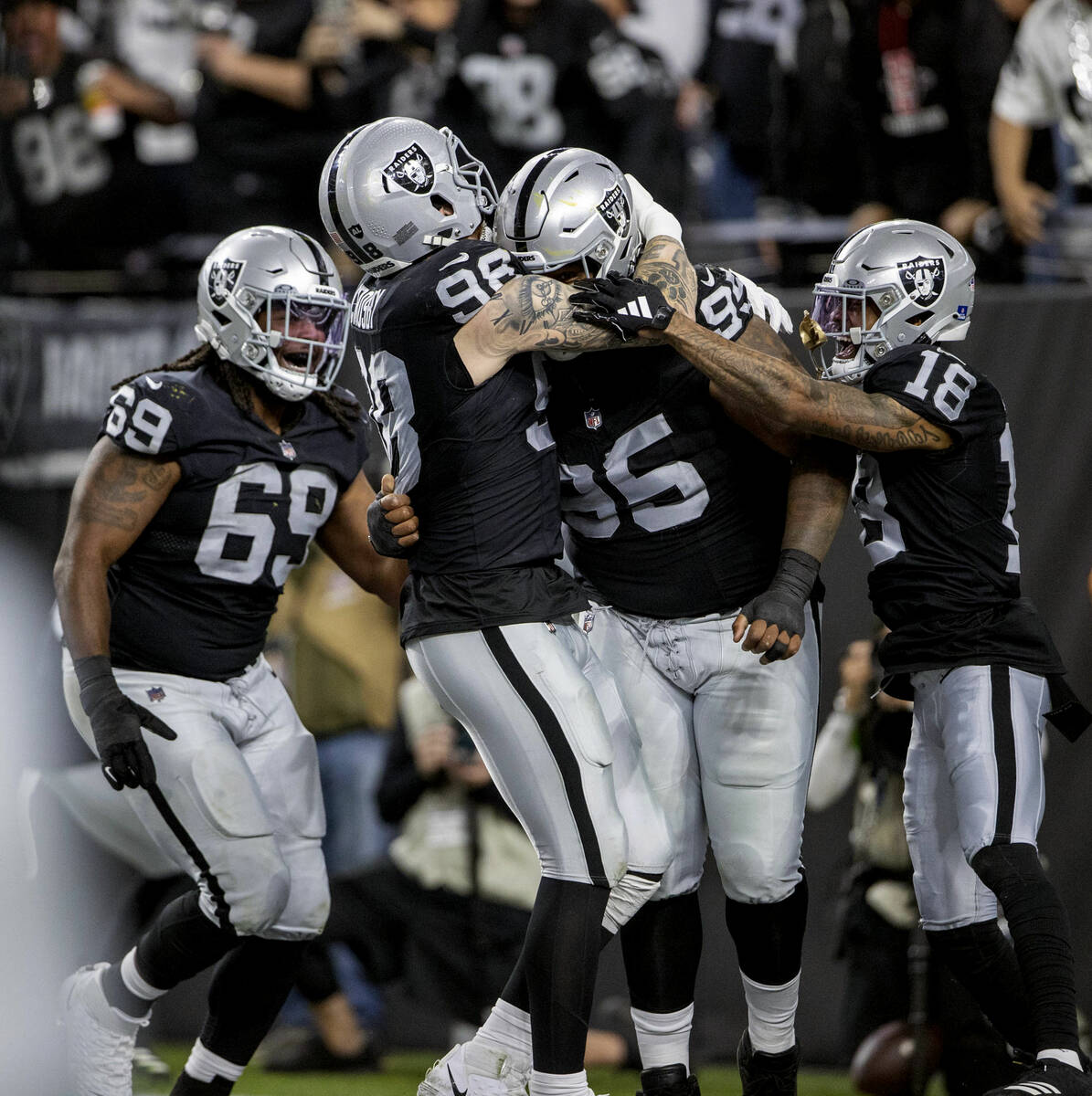 Raiders defensive end Maxx Crosby (98) congratulates defensive tackle John Jenkins (95) on his ...