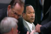 Former NFL great O.J. Simpson, center, watches lawyers confer in court at the Clark County Regi ...