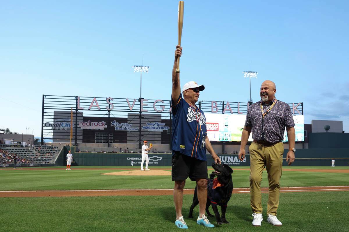 Fred Hassen holds up Finn the Bat Dog’s honorary golden bat next to Las Vegas Aviators g ...