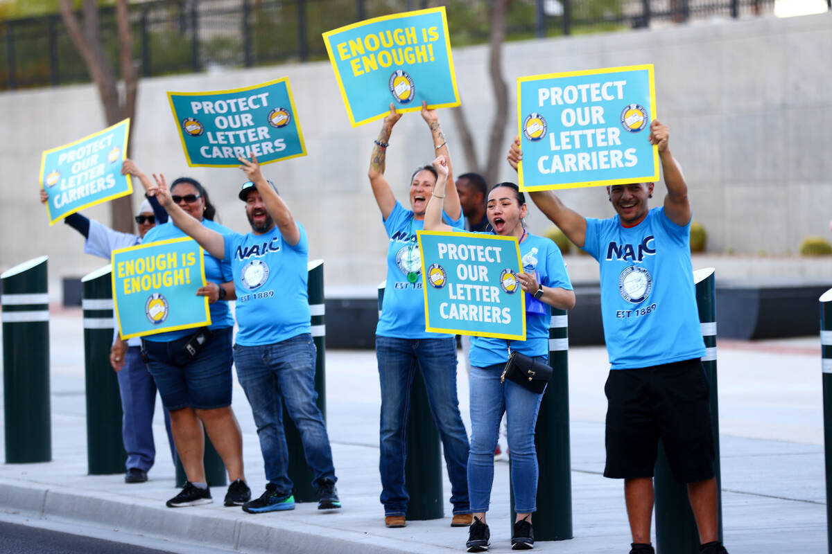 Postal workers grab the attention of passing traffic during a National Association of Letter Ca ...