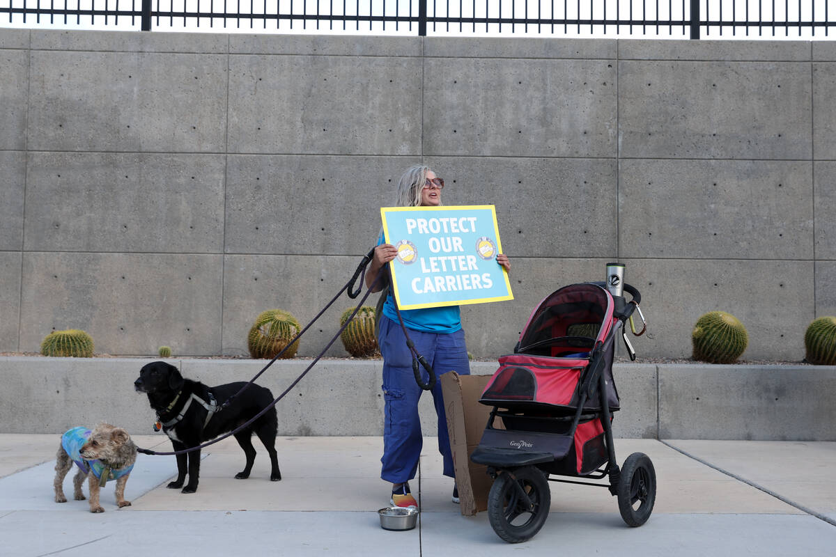 Laura Pavey, with her dogs Bambino and Lambert, chants a National Association of Letter Carrier ...