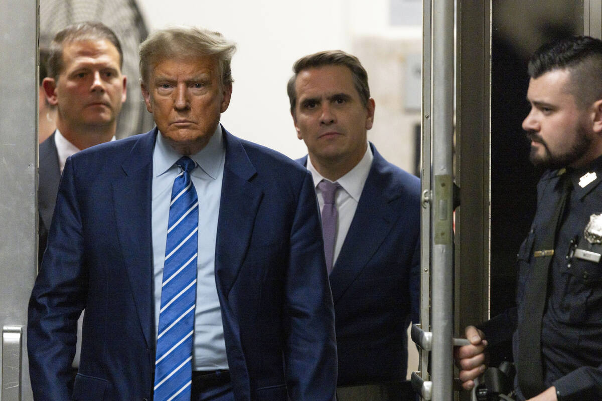 Former President Donald Trump walks through a doorway during the second day of jury selection, ...