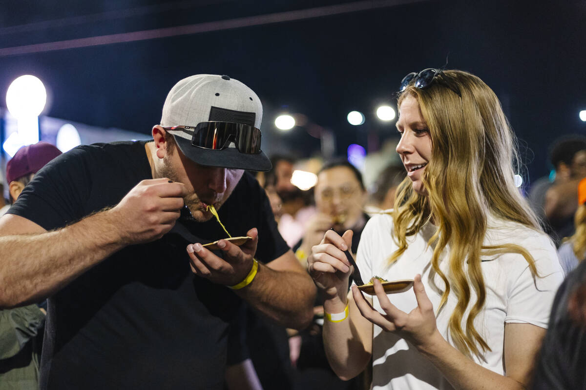 A couple, one slurping, at the 2023 Vegas Unstripped food and drink festival in downtown Las Ve ...