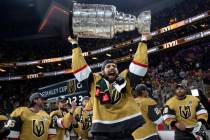 Golden Knights defenseman Nicolas Hague cheers while holding up the Stanley Cup after defeating ...