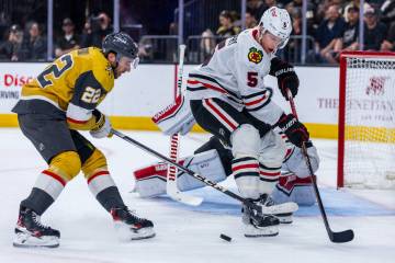 Golden Knights right wing Michael Amadio (22) battles for the puck against Chicago Blackhawks d ...