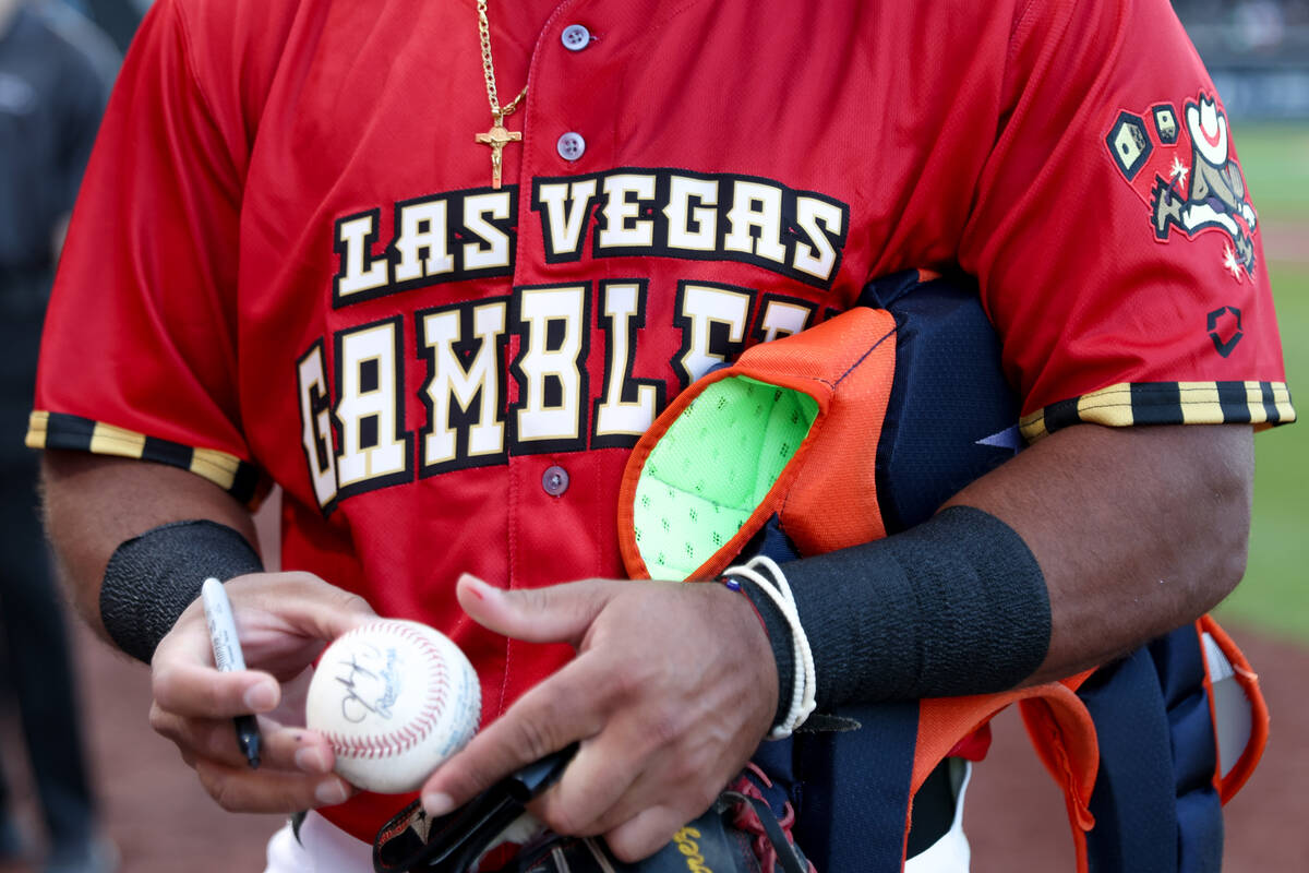 Las Vegas Aviators catcher Carlos Pérez, wearing a Las Vegas Gamblers jersey, signs autogr ...