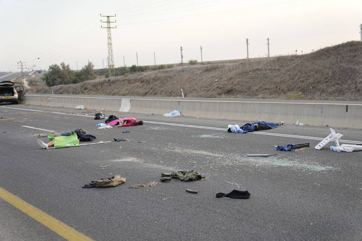 FILE - Israelis killed by Hamas militants lie on the road near Sderot, Israel, on Saturday, Oct ...