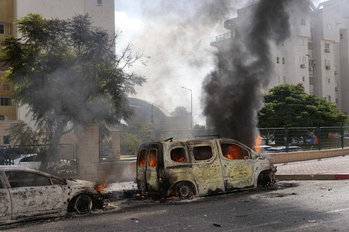 FILE - Cars are on fire after they were hit by rockets from the Gaza Strip in Ashkelon, Israel, ...