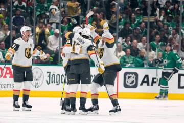 Vegas Golden Knights' Noah Hanifin (15) celebrates with Mark Stone (61), Tomas Hertl, front rig ...