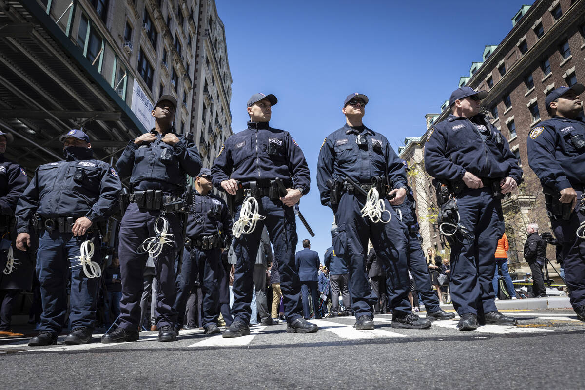 NYPD officers from the Strategic Response Group form a wall of protection around Deputy Commiss ...