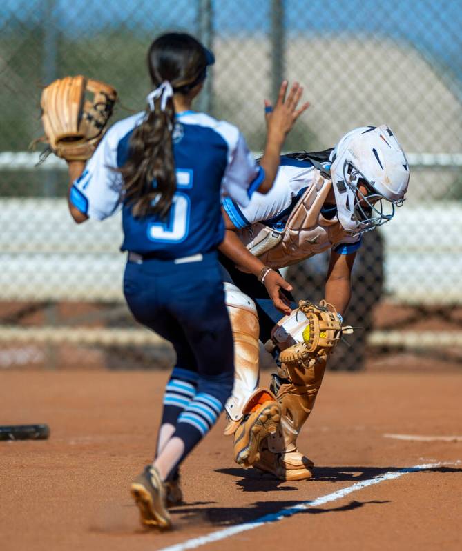 The Centennial catcher scooped up a bunt as infielder Valeria Lopez (5) runs in against a Palo ...