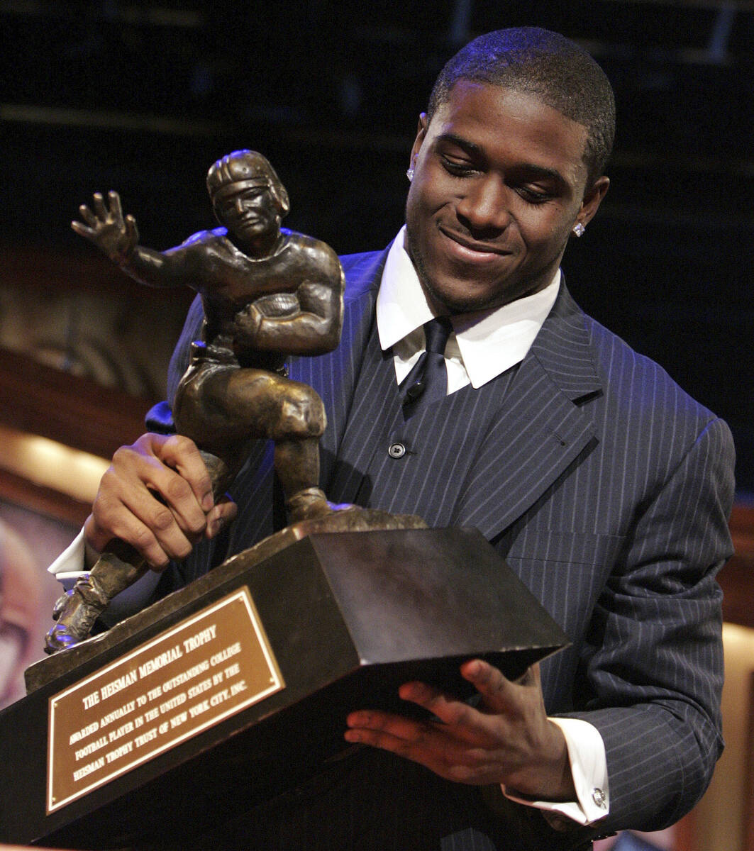 Southern California tailback Reggie Bush picks up the Heisman Trophy after being announced as t ...