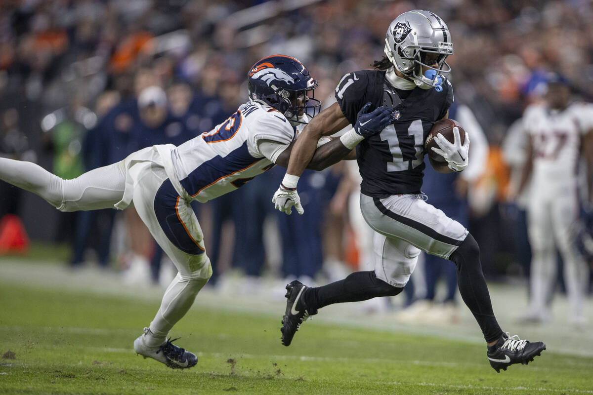 Denver Broncos cornerback Ja'Quan McMillian (29) can’t tackle Raiders wide receiver Tre ...