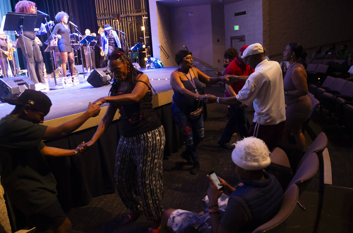 Attendees dance as Vegas Groove & The Silver State Horns perform during an event celebratin ...